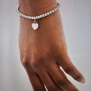 Tiffany & Co. Silver Bracelet with Pink Heart Enamel Charm Collection.